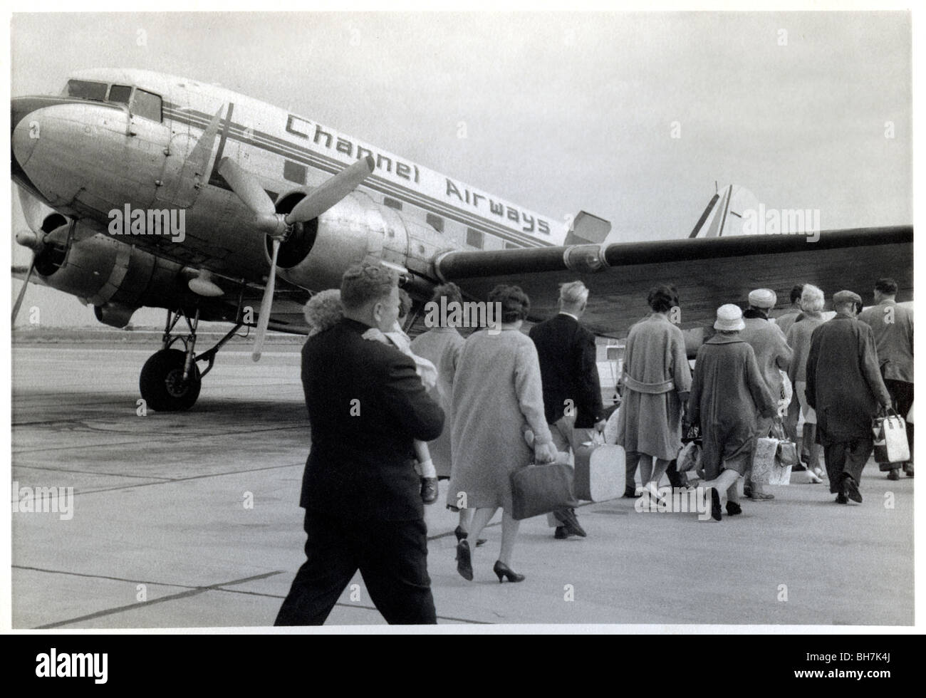 VINTAGE AIRLINE PASSENGERS 1950’s-1960s Air Travel foreign post- war holiday abroad flying boarding travel  B+W image of intrepid English holidaymakers boarding a DC3 Aircraft Channel Airways Airline flight to Ostend Belgium Stock Photo