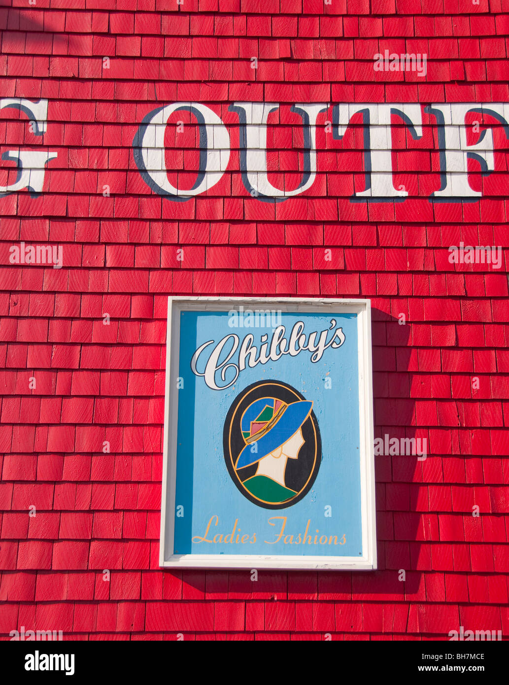 Nova Scotia, Lunenburg, Colorful red painted building with sign advertising Ladies Fashions. World Heritage UNESCO Site Stock Photo