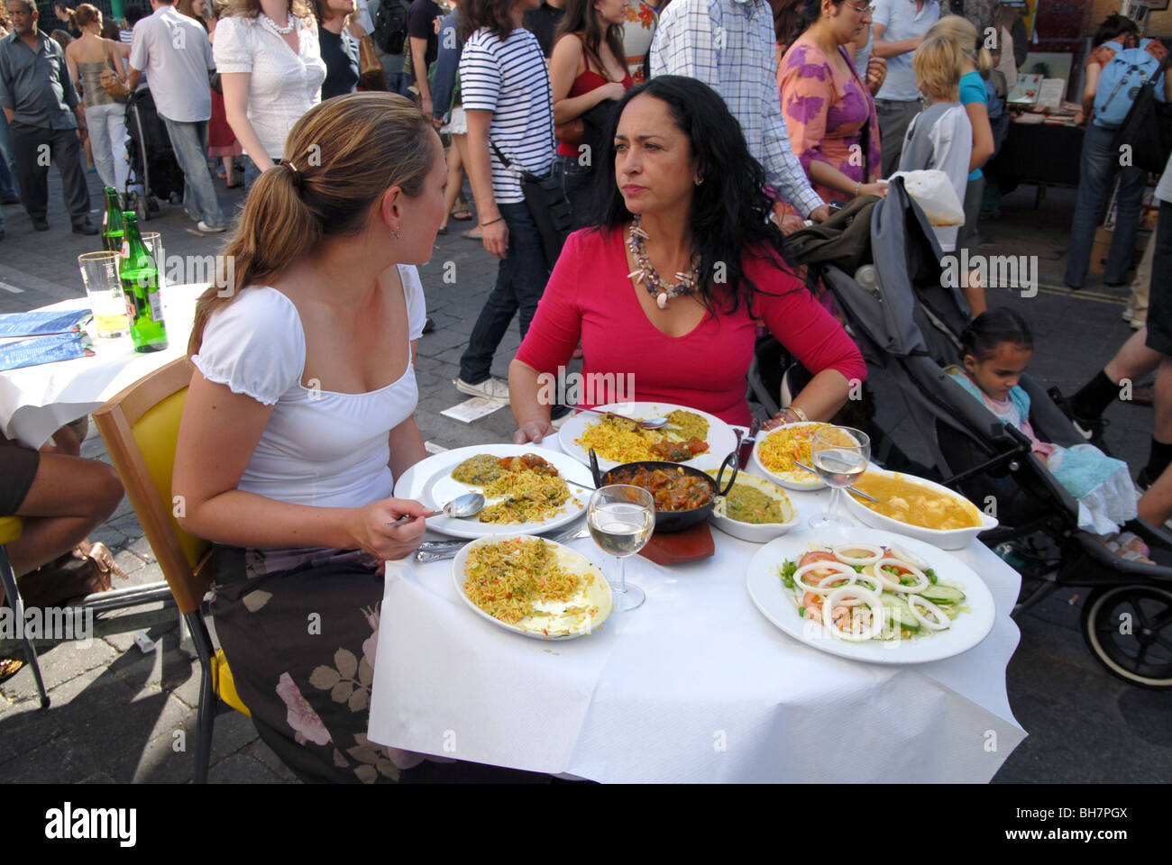 UK. Eating curry in the streets at the Brick Lane Curry Festival in