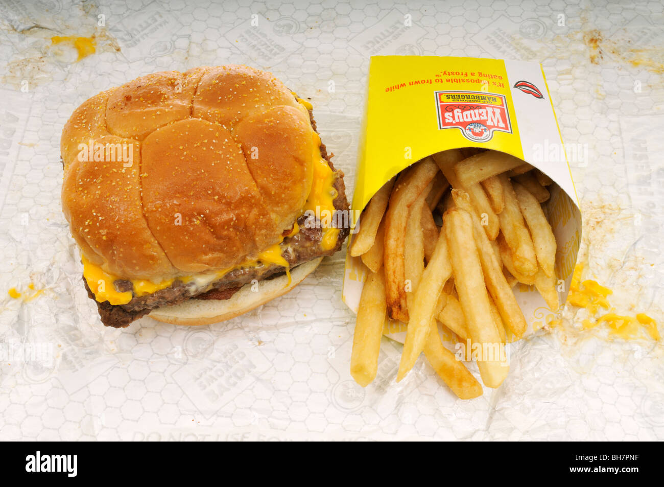 Wendy's take out fast food bacon double cheeseburger and french fries on wrapper Stock Photo