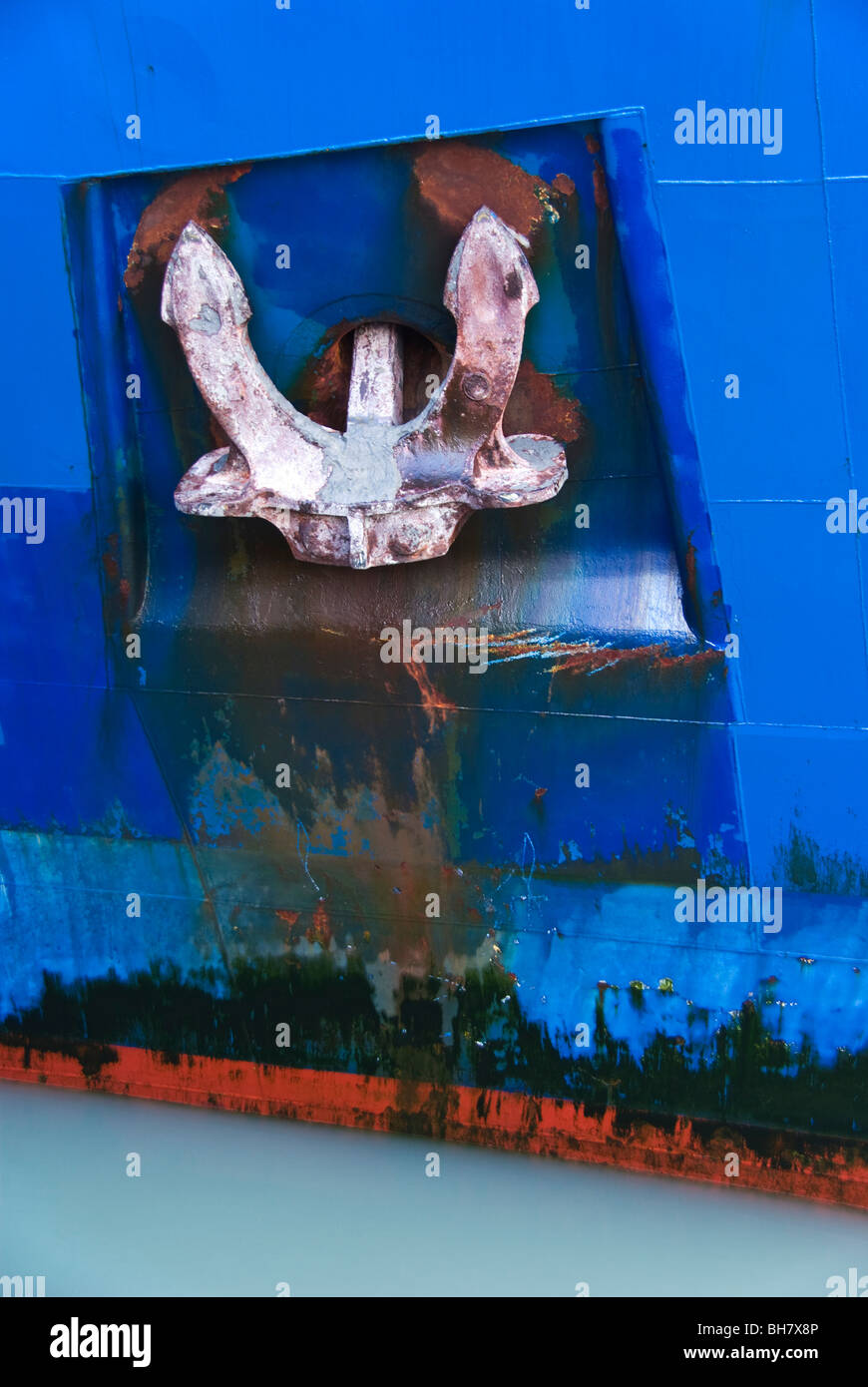 A close up view of a ship's anchor housed in it's hawse pipe recessed