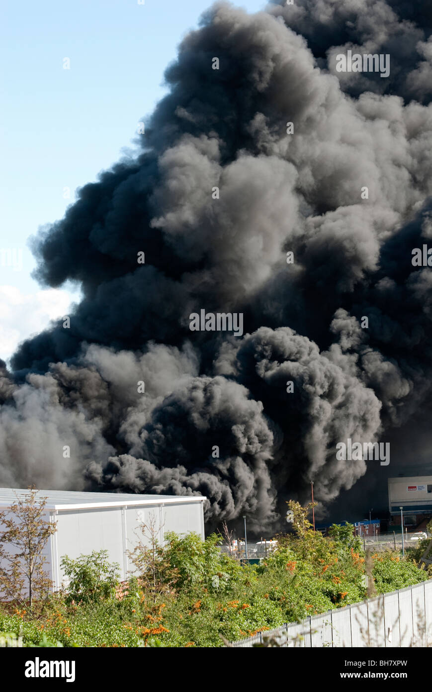 Huge plume of black smoke at factory fire Stock Photo