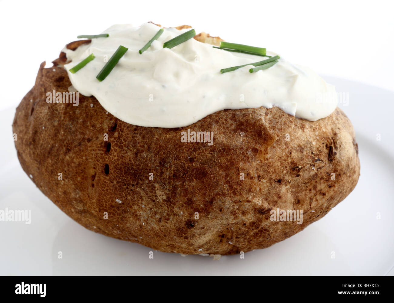A baked Russet potato served with a topping of cream cheese, chives and