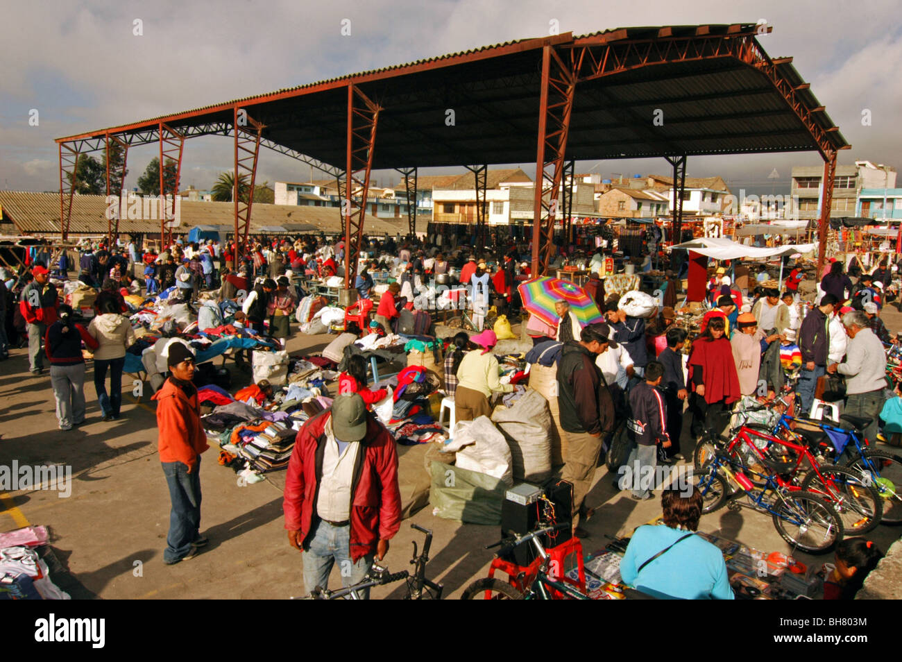Ecuador, Saquisili, crowded market area with a roofed structure and buildings in the background, with people buying, window shop Stock Photo