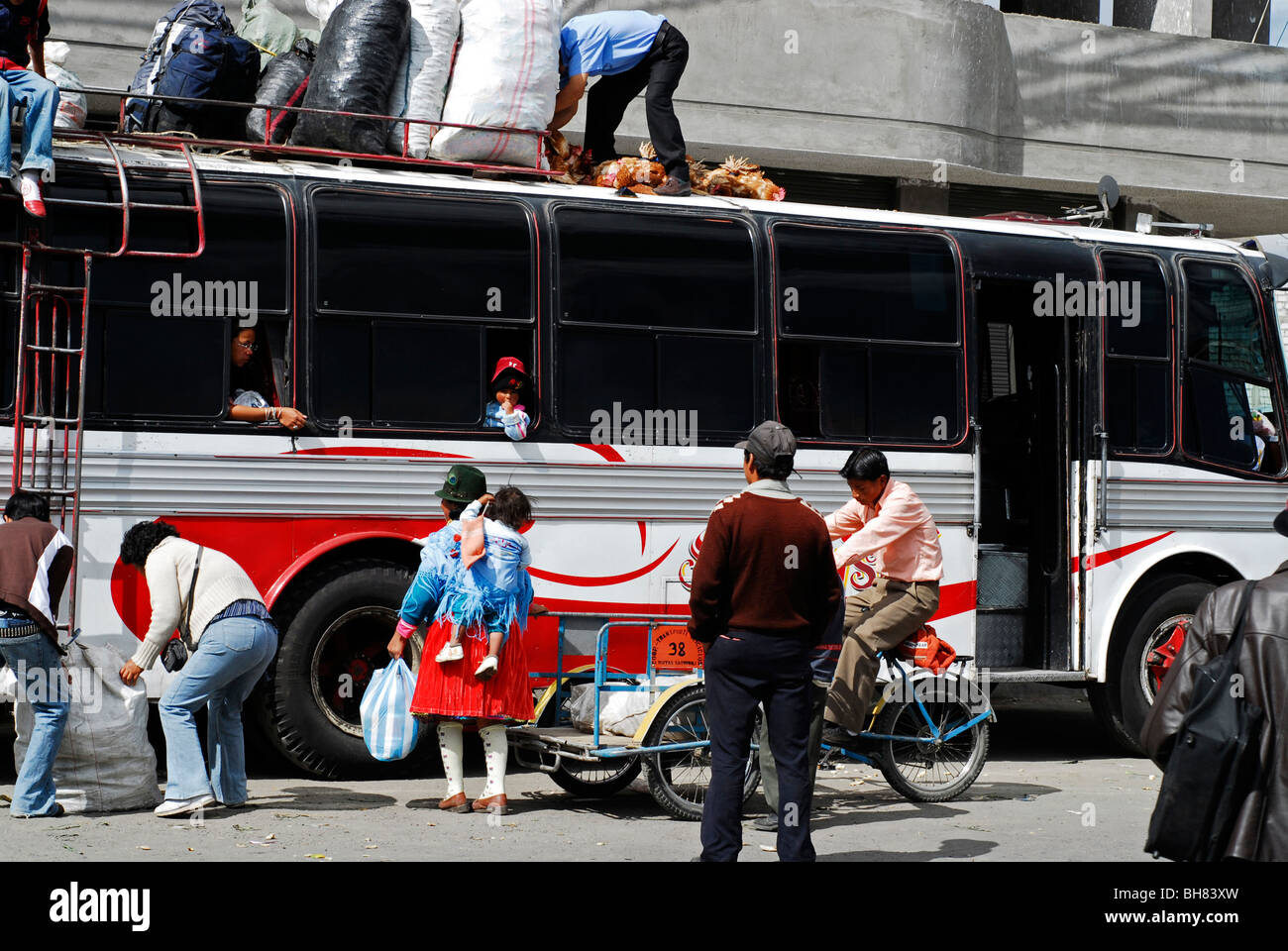 Ecuador, Saquisili, view of people standing near loaded bus by wheeled