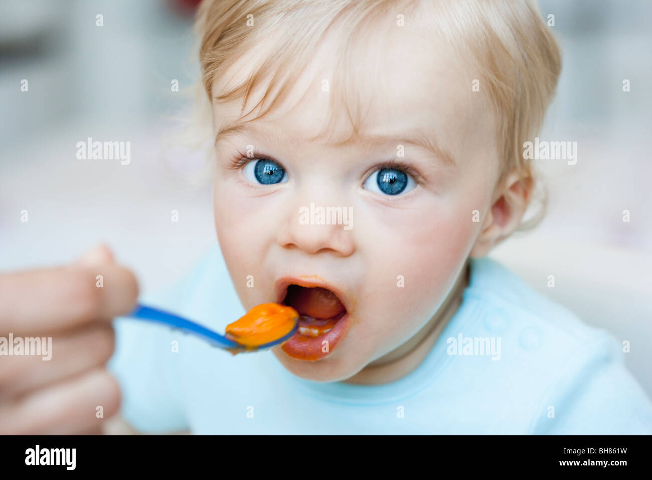 baby being fed looking at viewer Stock Photo