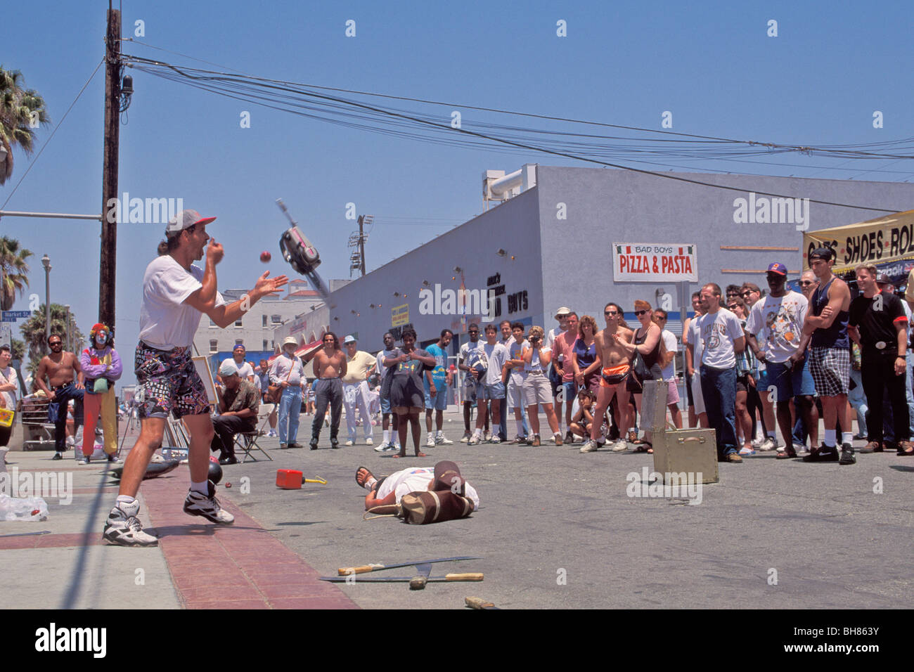 Street Entertainer Juggling Chain Saw And Bowling Ball On Boardwalk Venice Beach Los Angeles California Stock Photo