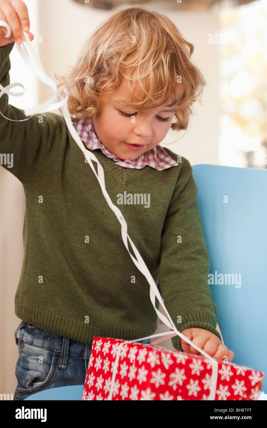 Young boy opening christmas present Stock Photo