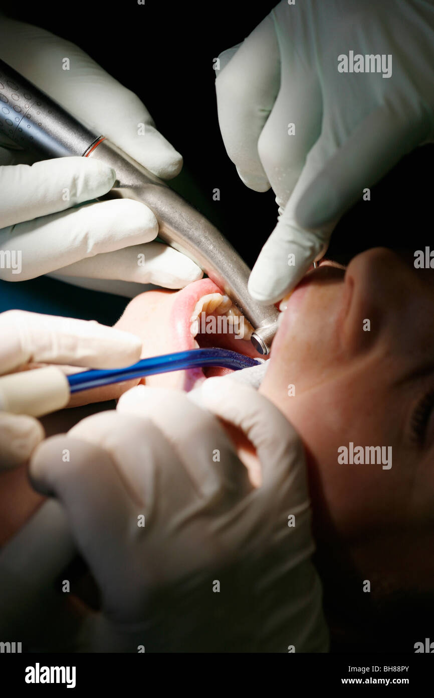 Close-up of a dentist and a dental assistant working on a female patient Stock Photo