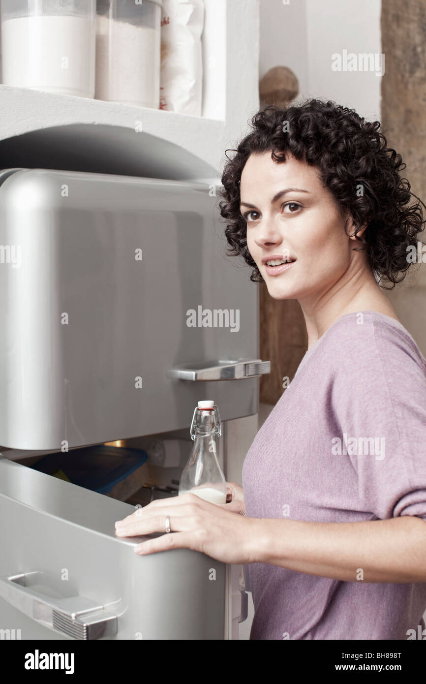 A woman putting milk in the fridge Stock Photo