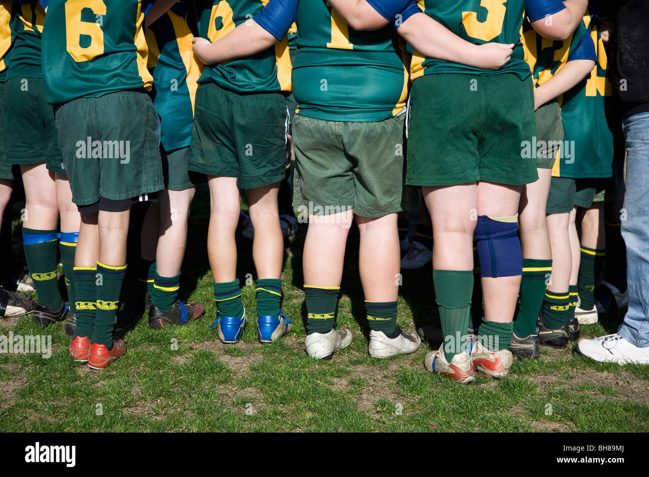 Rear view of a football team huddled together Stock Photo