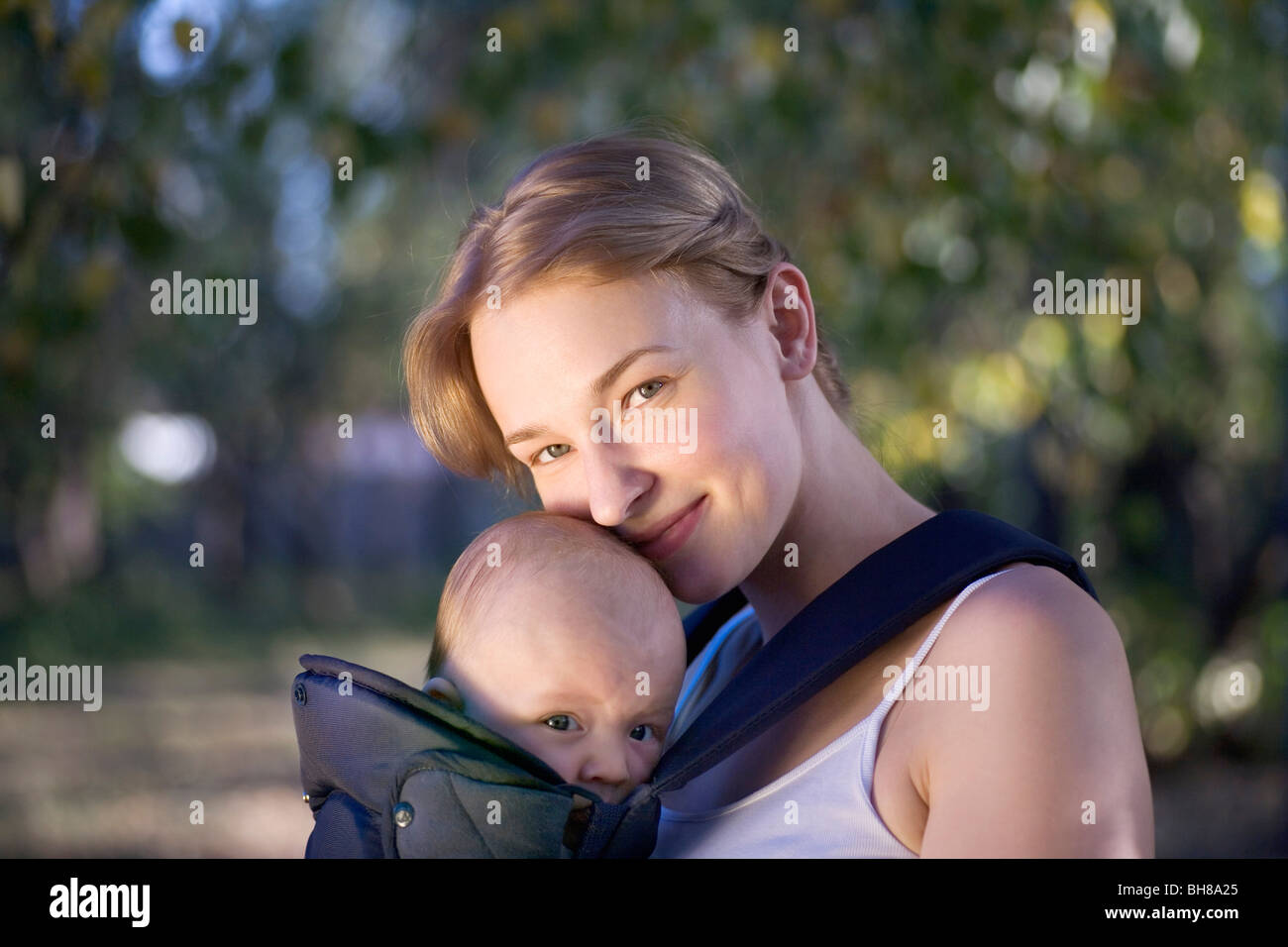 A mother with her baby in a baby carrier, portrait Stock Photo