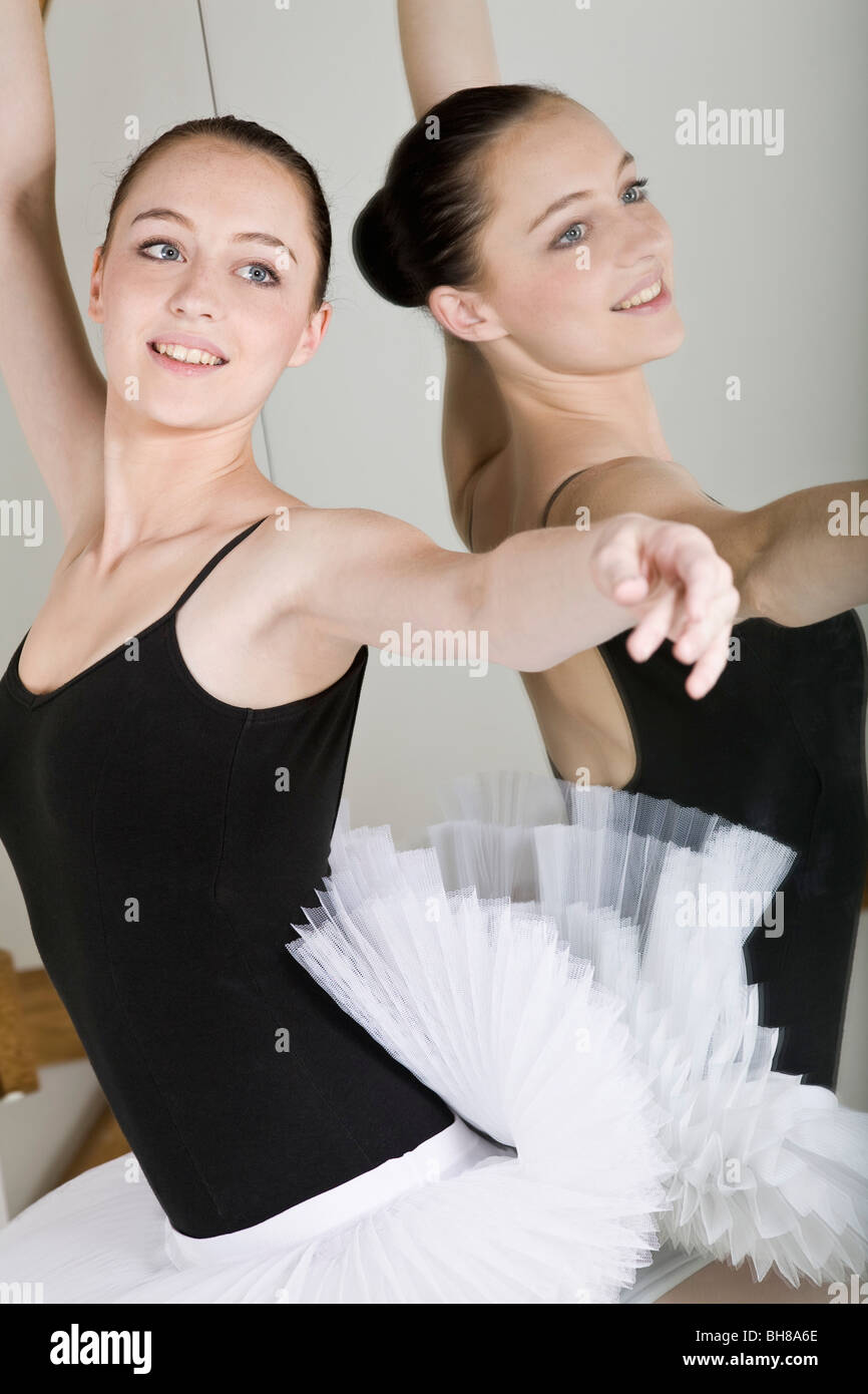 A ballet dancer posing next to a mirror in a ballet studio Stock Photo