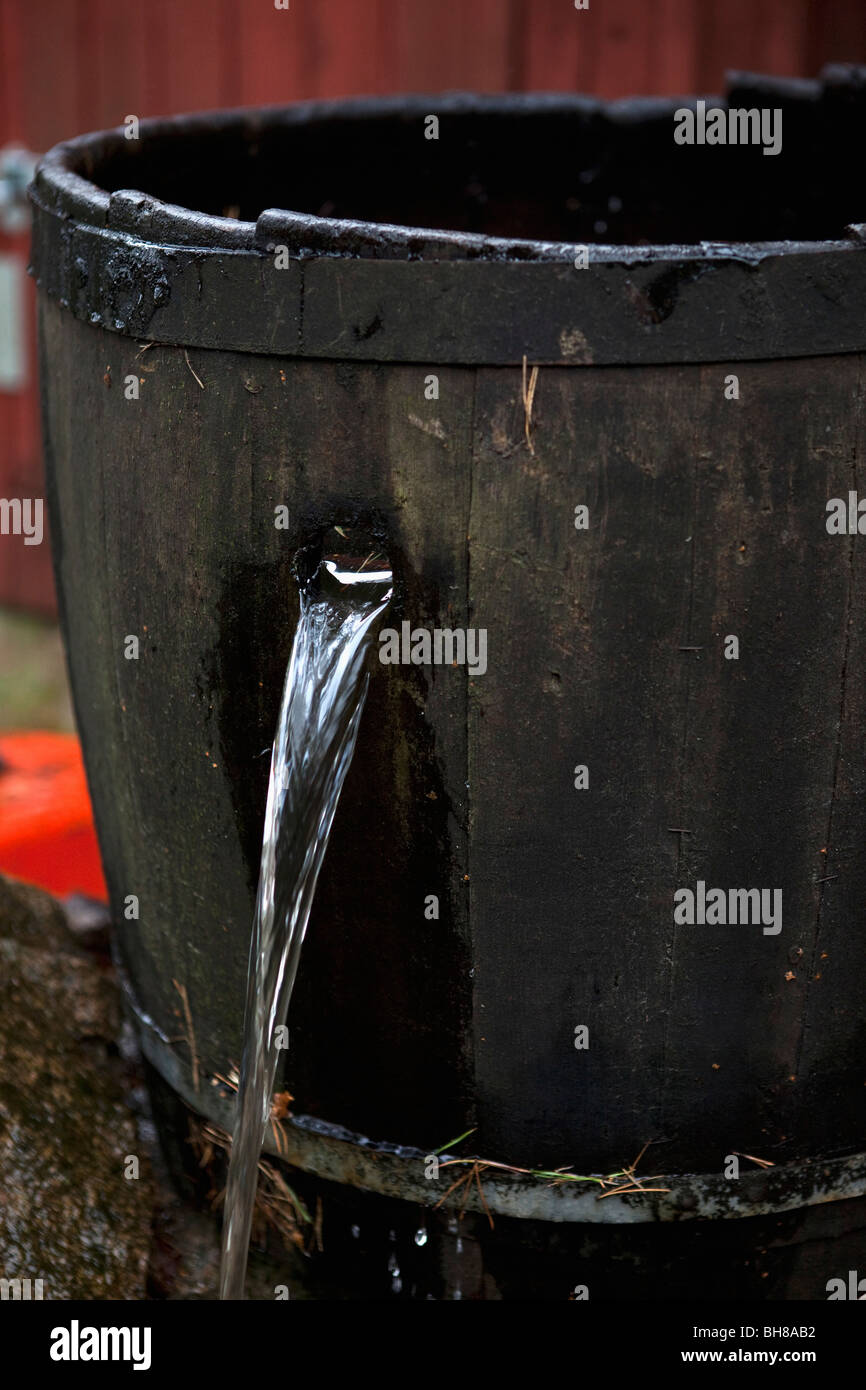 Water pouring out of a hole in a bucket Stock Photo Alamy