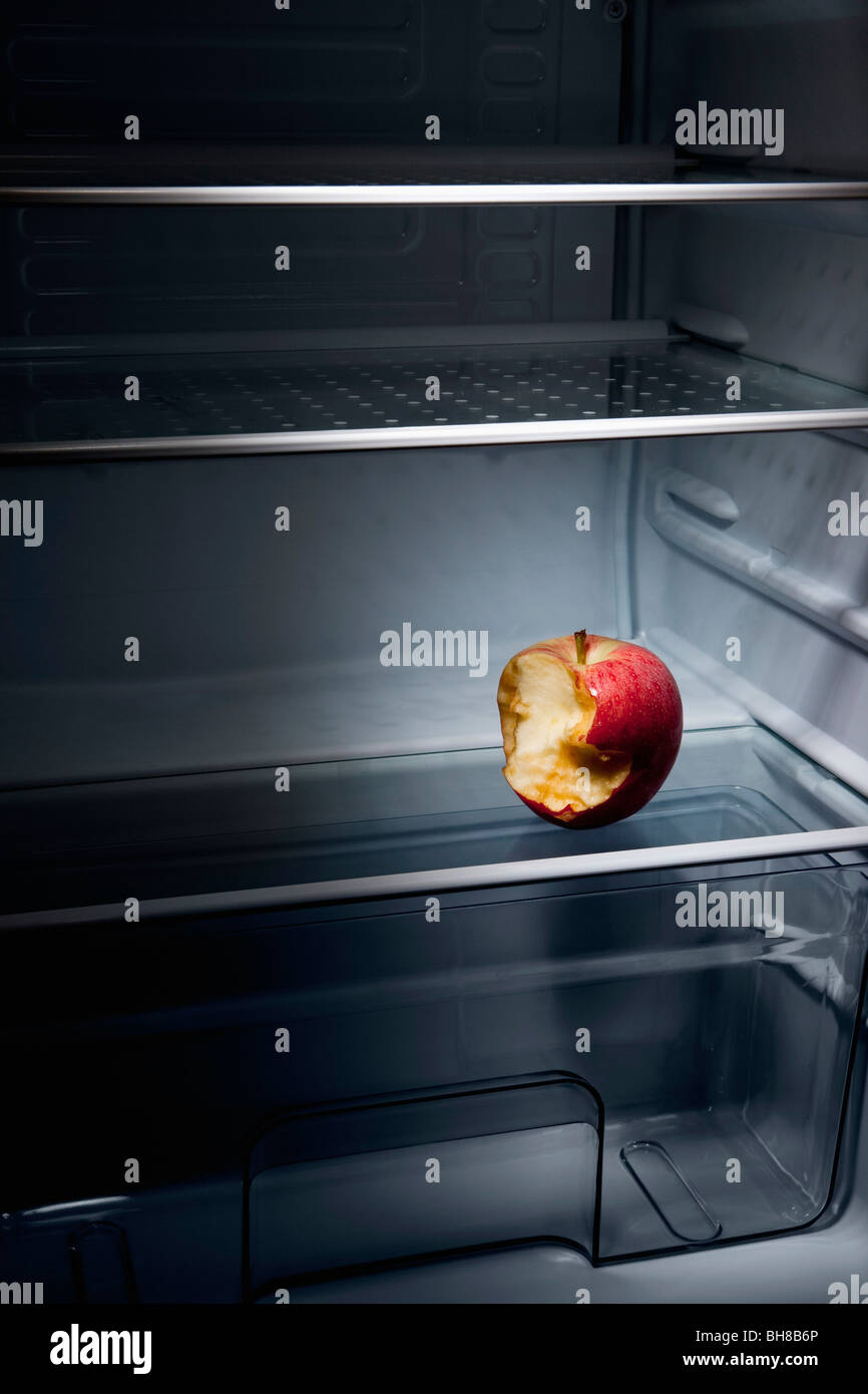 A half eaten apple in an empty refrigerator Stock Photo