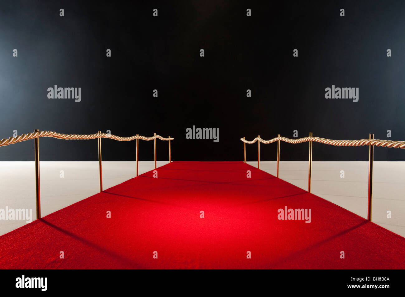 View down red carpet with rope barriers Stock Photo