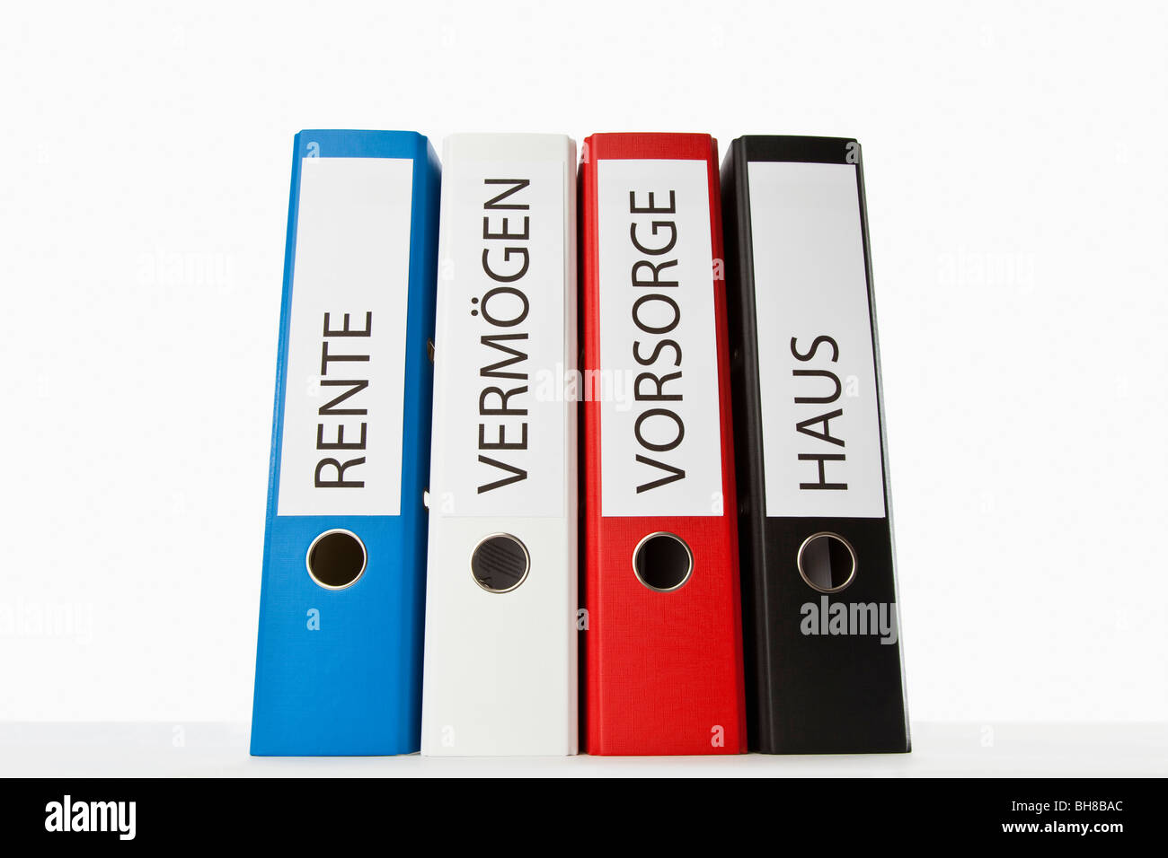 Four colored ring binders with the German words for Pension, Retirement