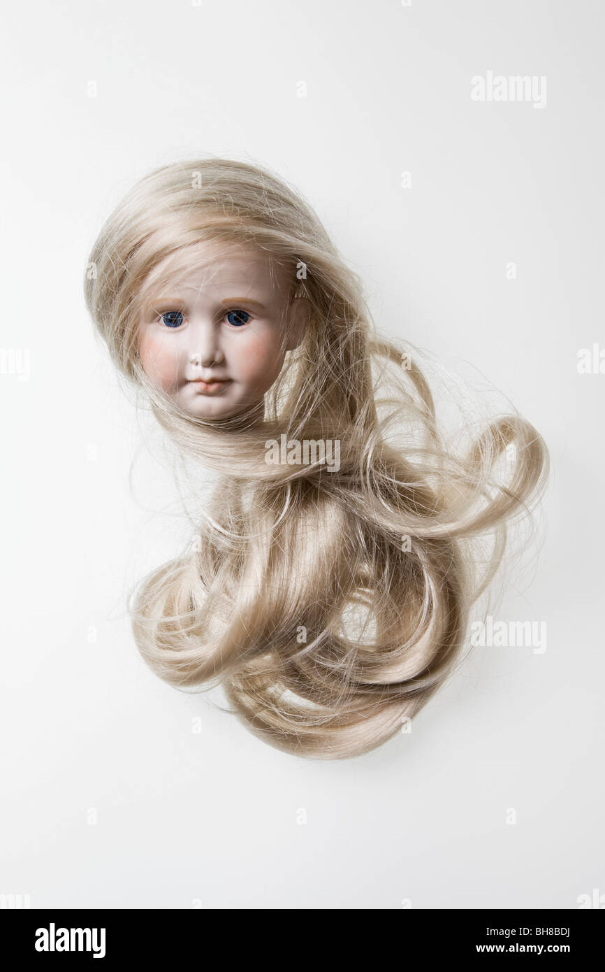 The head of a porcelain doll with long blond hair Stock Photo