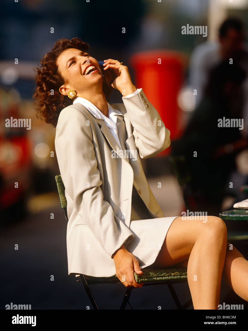 Dark haired girl sitting and laughing Stock Photo