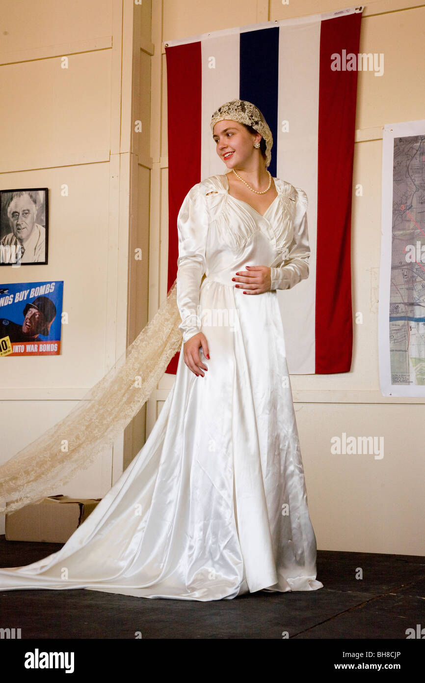 Bride in 1940s wedding dress posing in front of flag during a reenactment  of a World War II fashion show Stock Photo - Alamy