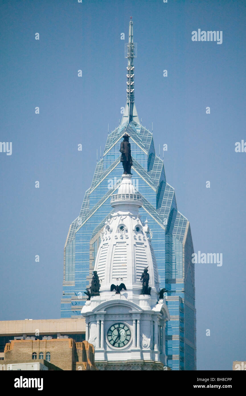 Statue of William Penn on the top of the renovated City Hall and a modern office building behind it in Philadelphia, PA Stock Photo