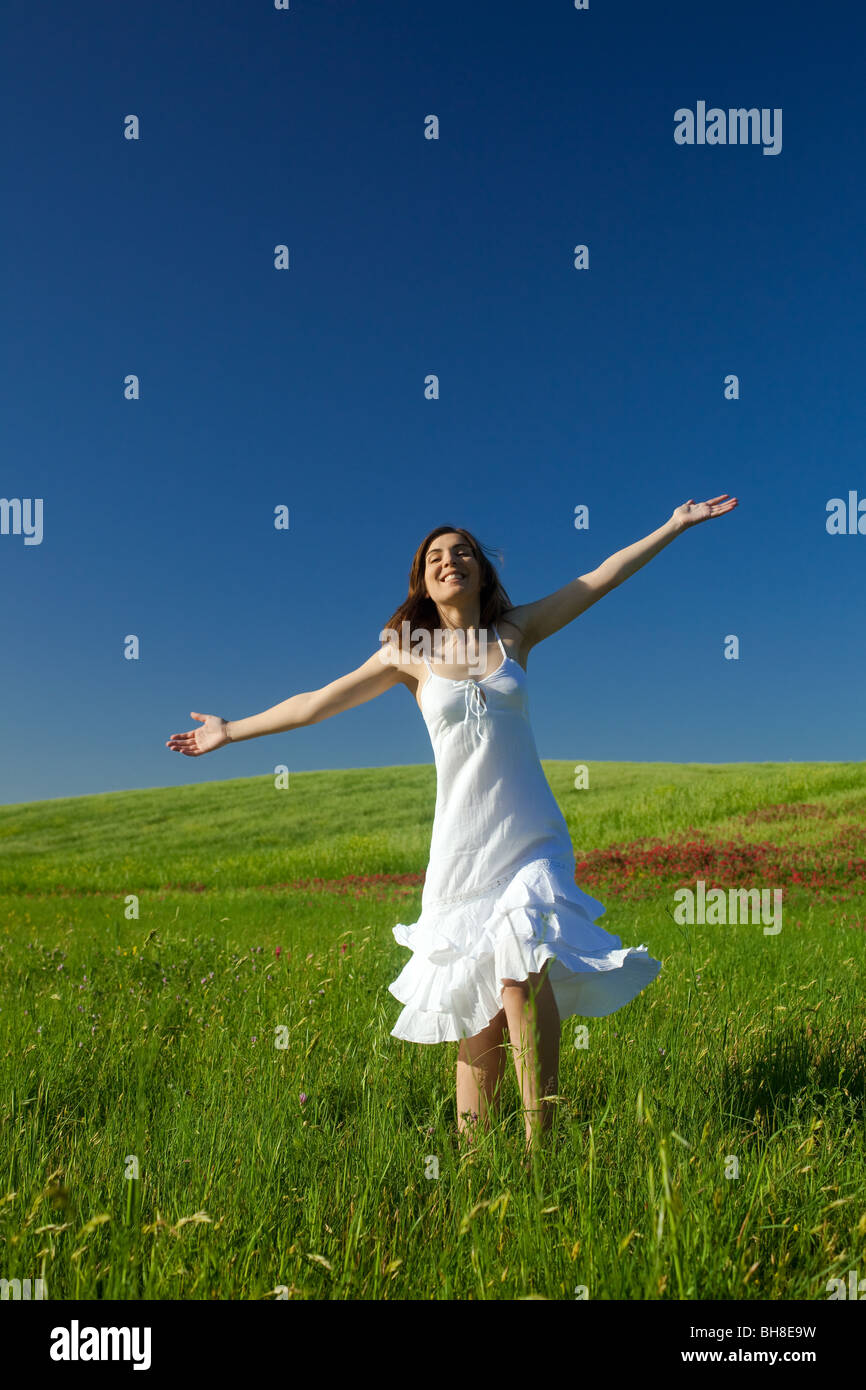 Beautiful happy young woman dancing on the field Stock Photo - Alamy