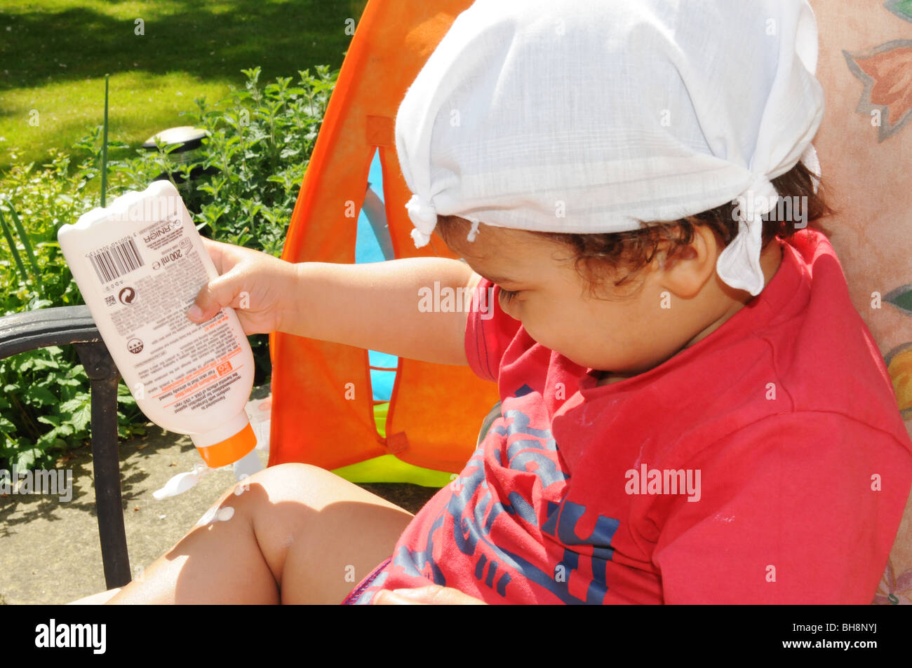 2 year old boy wearing sunscreen and sun hat Stock Photo