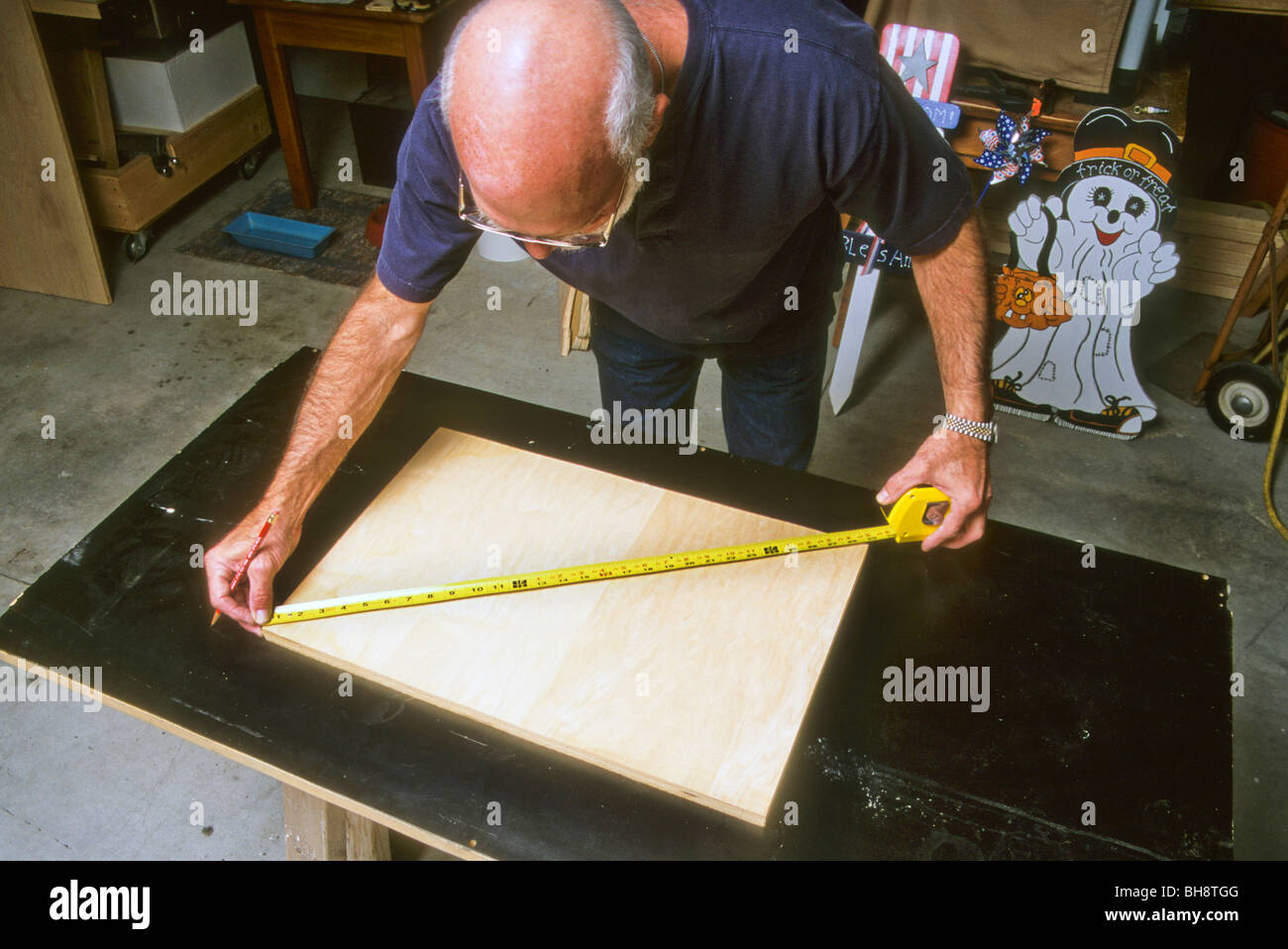 man measure diagonal tape line wood work make build carpenter hobby workshop square Stock Photo