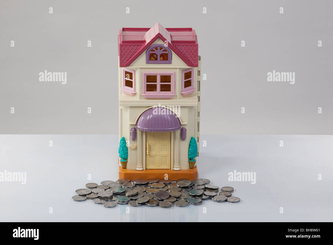 Toy house and coins Stock Photo Alamy