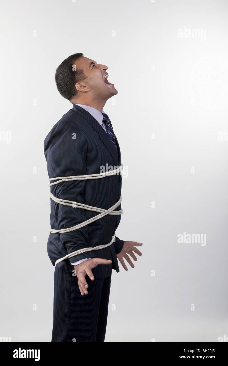 Businessman tied up with rope Stock Photo