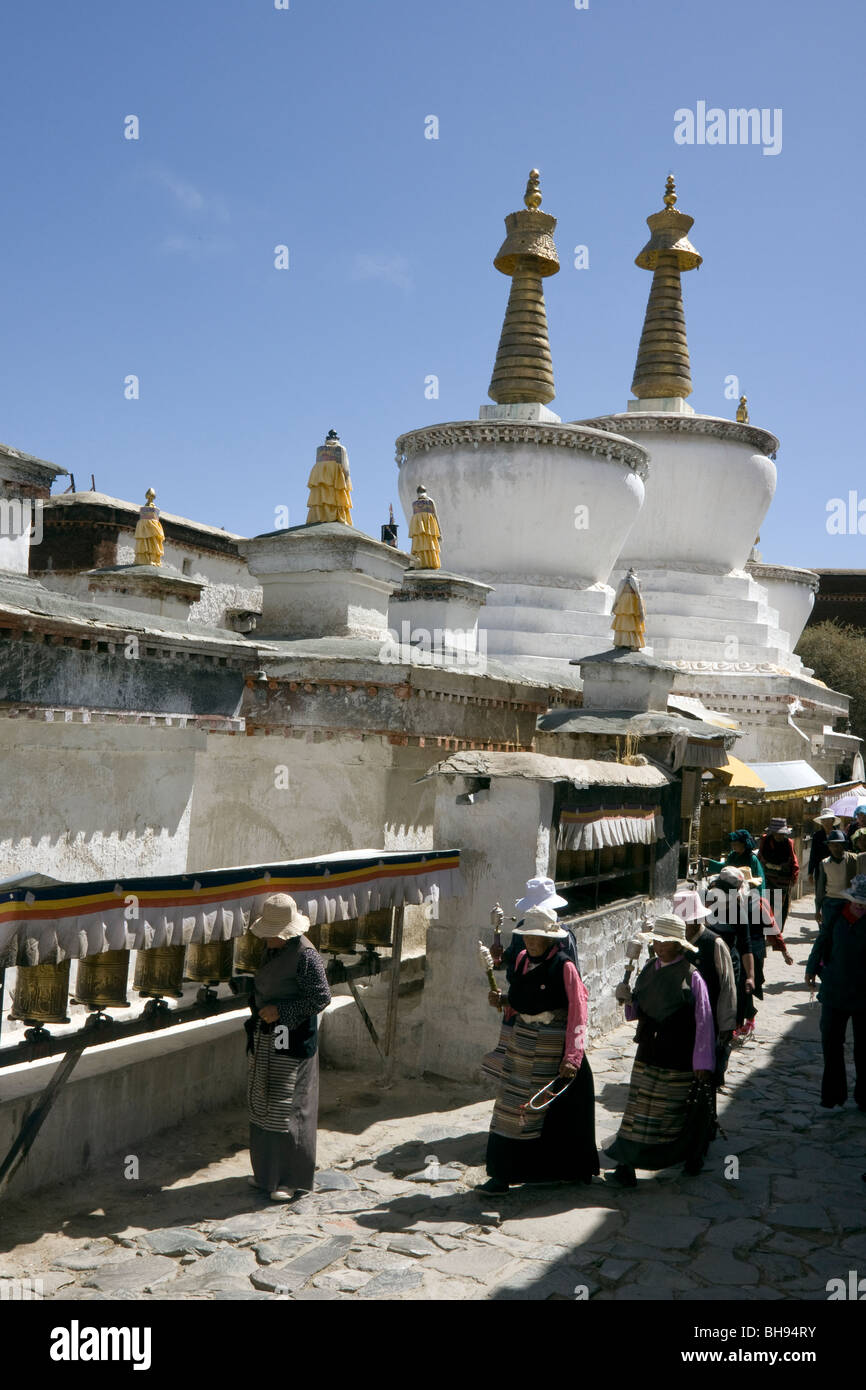 devotees turning the prayer wheels walking round the stupas at the tashilhunpo monastery in shigatse tibet Stock Photo