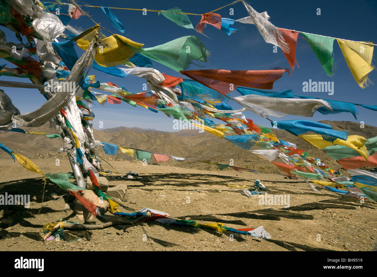 prayer flags and mountains at the summit of the tsuo la pass on the friendship highway tibet Stock Photo