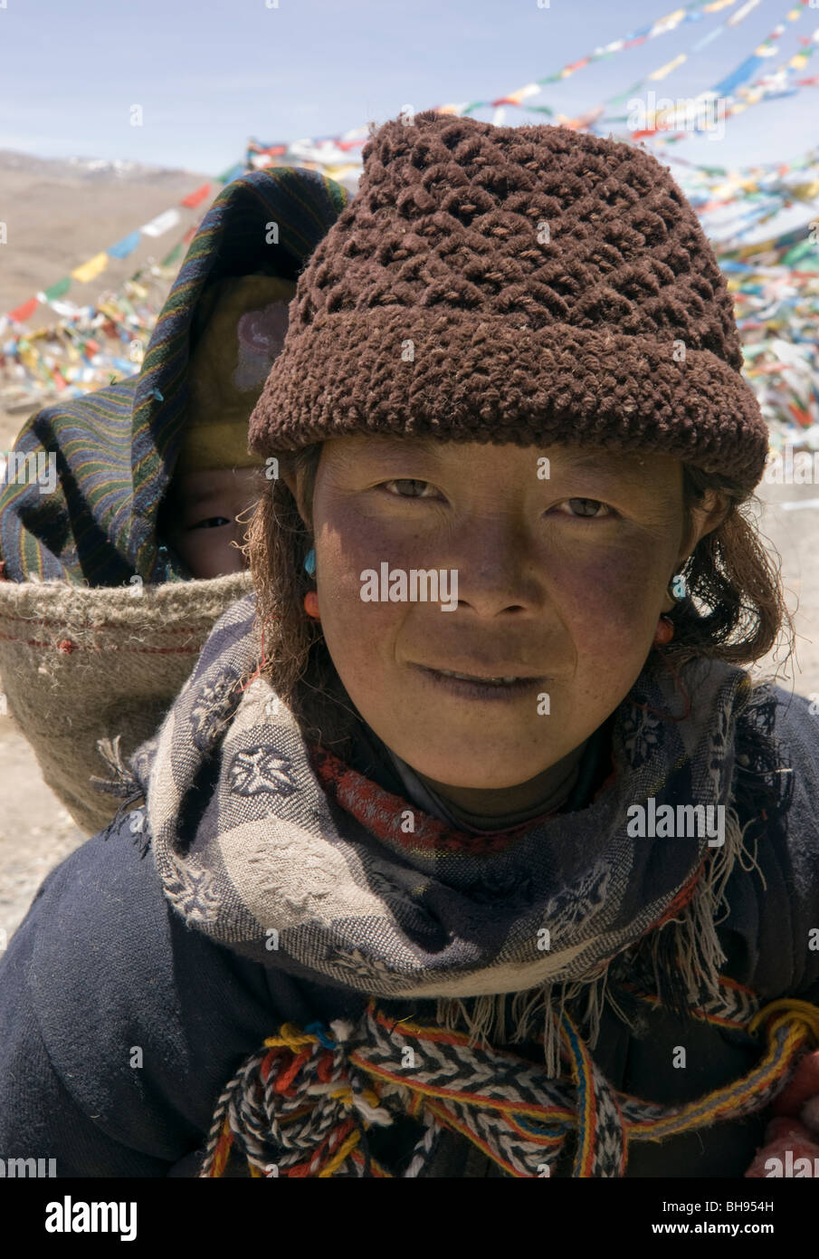 portrait of tibetan mother and child on her back on the friendship highway at the jia tsuo la pass Stock Photo