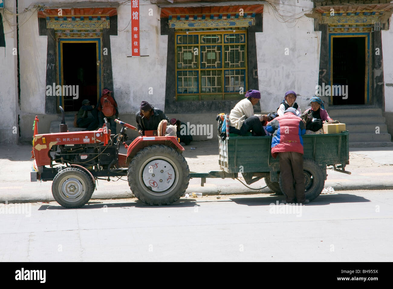 local tibetan people with tractor and cart in the village of baber on the friendship highway Stock Photo