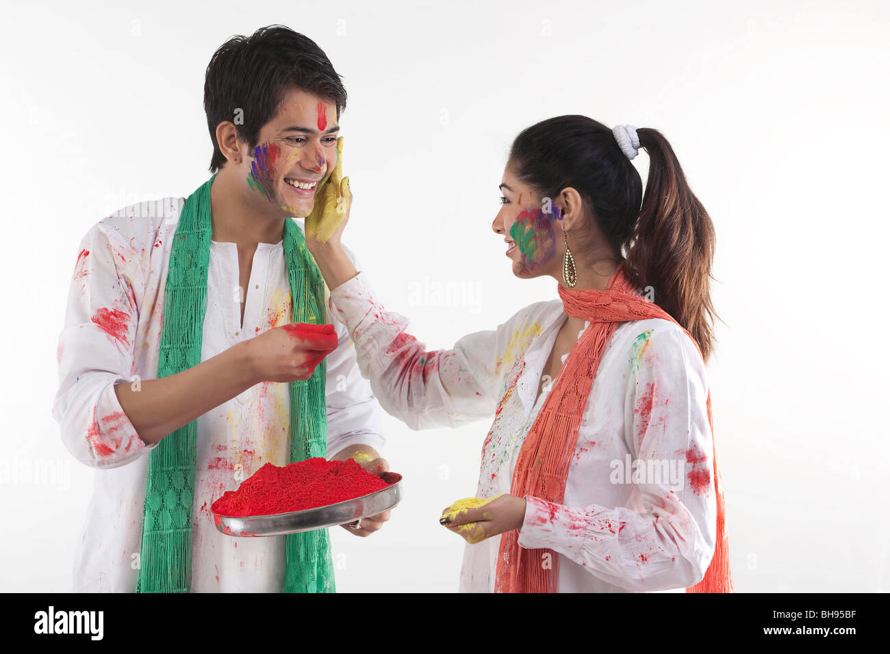 Woman putting colour on a man's face Stock Photo
