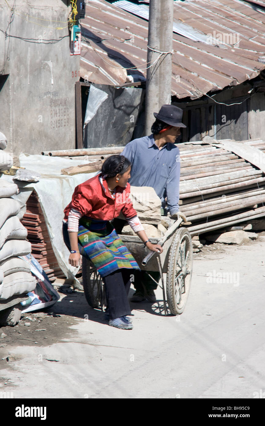 two tibetan construction workers with hand cart in the back street of zhangmu border town Stock Photo