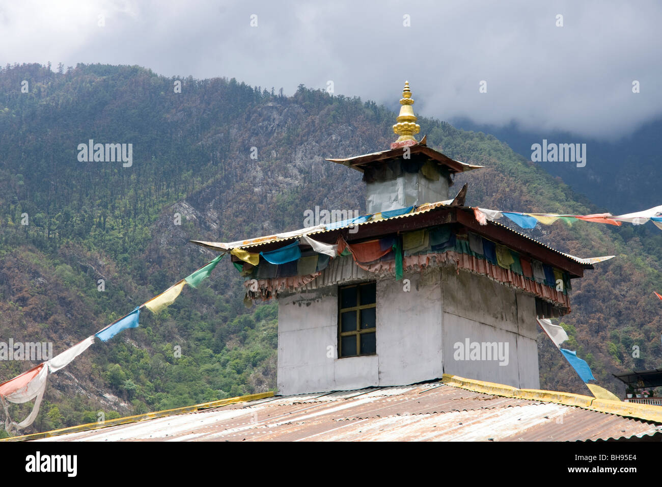 temple roof of corrugated iron with prayer flags in the tibetan border town of zhangmu Stock Photo