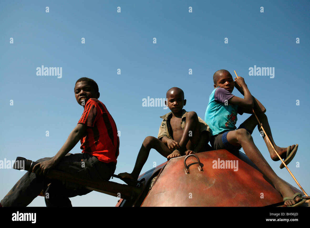 Angolan children play on an old tank on a former battle field at Cuito Cuanavale, Angola, Africa. Stock Photo