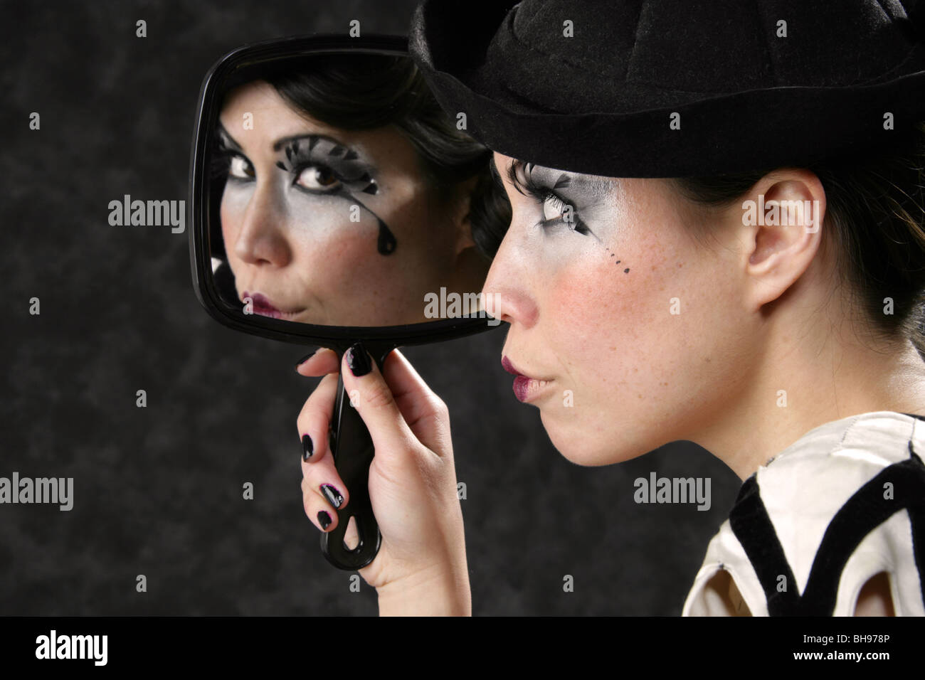 Young Woman Looking at Her Reflection in a Hand Mirror Stock Photo