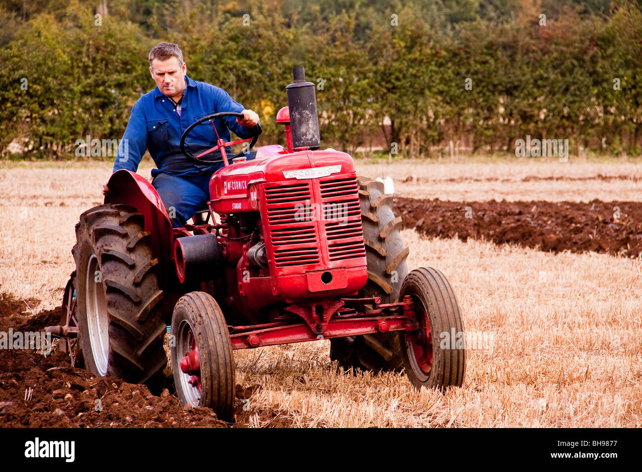 Man ploughing on tractor in paddock Stock Photo