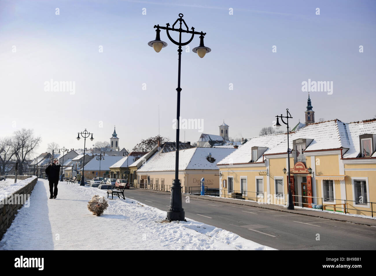 Winter scene in Szentendre Hungary with a man walking a traditional Hungarian Puli Sheepdog Stock Photo