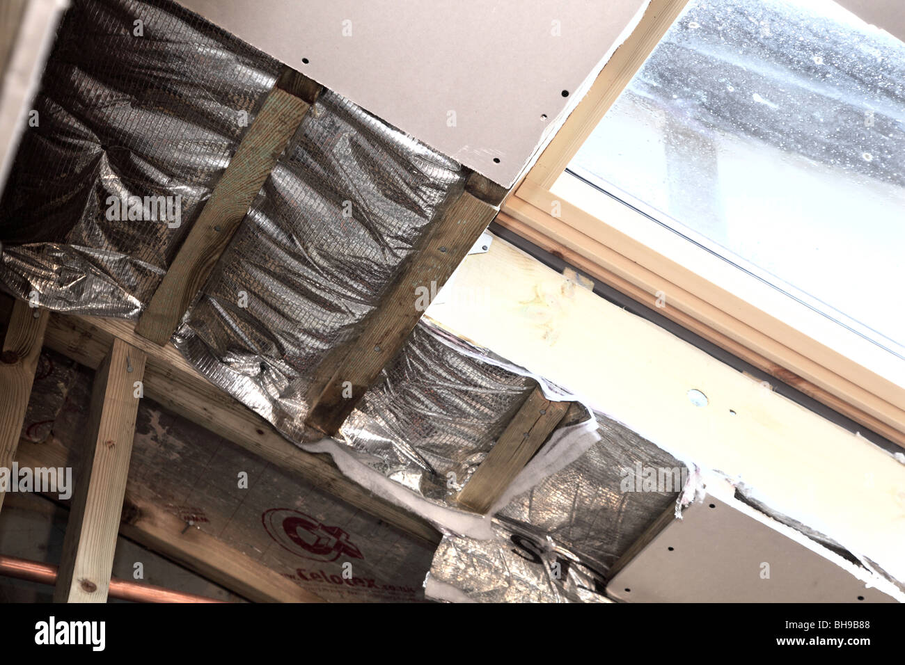 Installation of foil roof insulation in a domestic property Stock Photo
