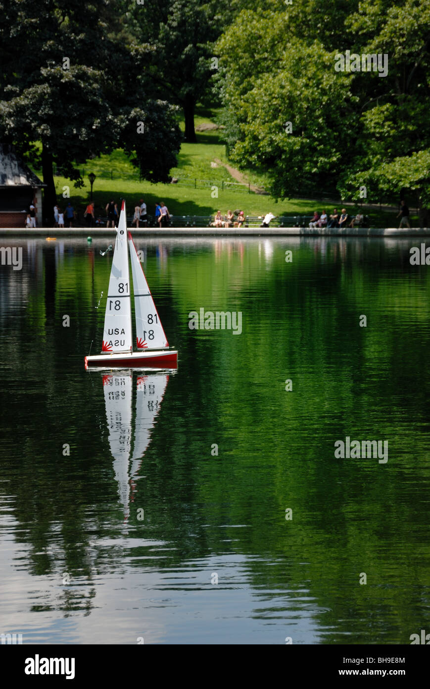 A model sailboat glides across the water at the Model Boat Basin in Central Park, New York city. Stock Photo