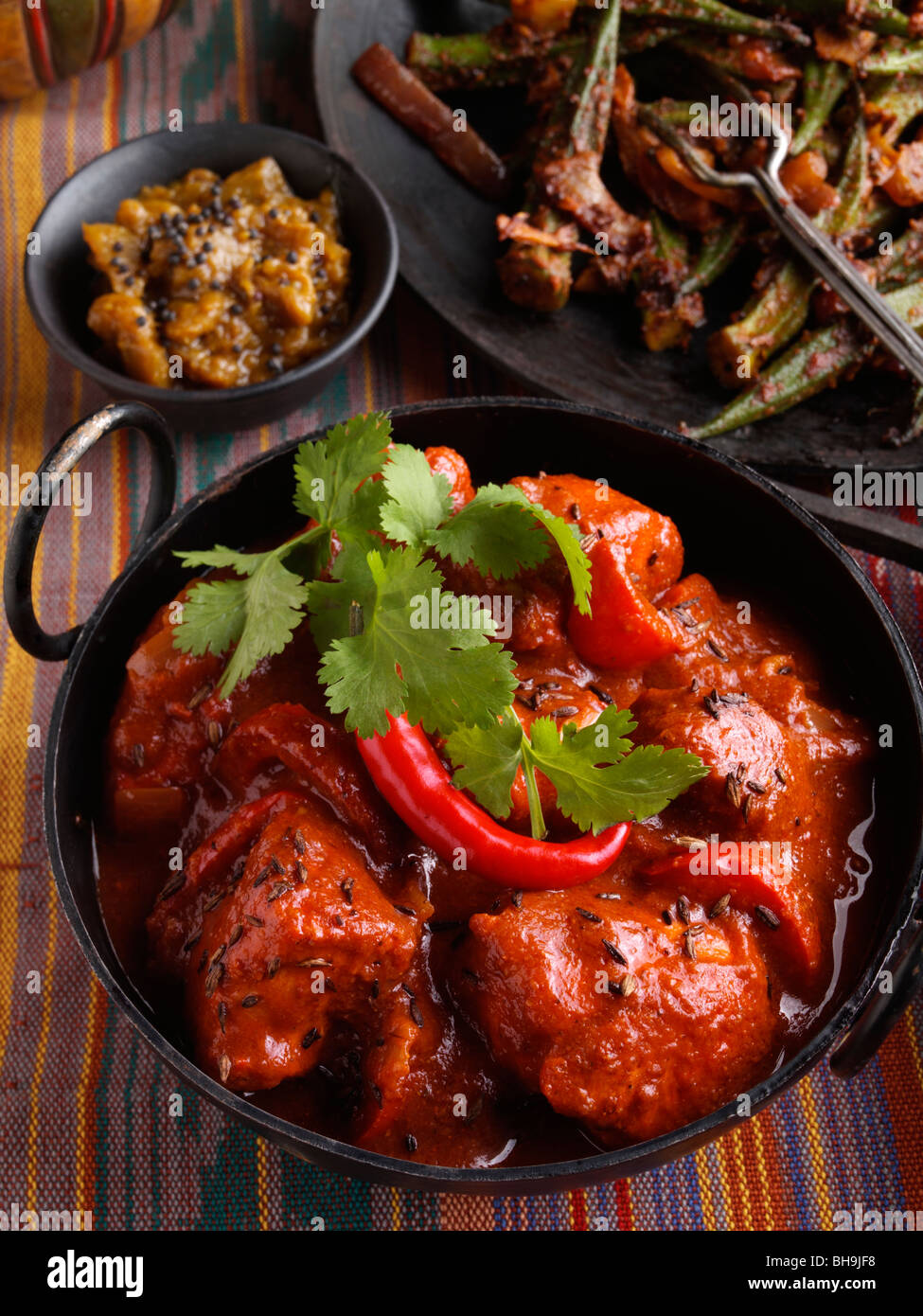 Chicken vindaloo Indian hot curry okra and aubergine chutney Stock