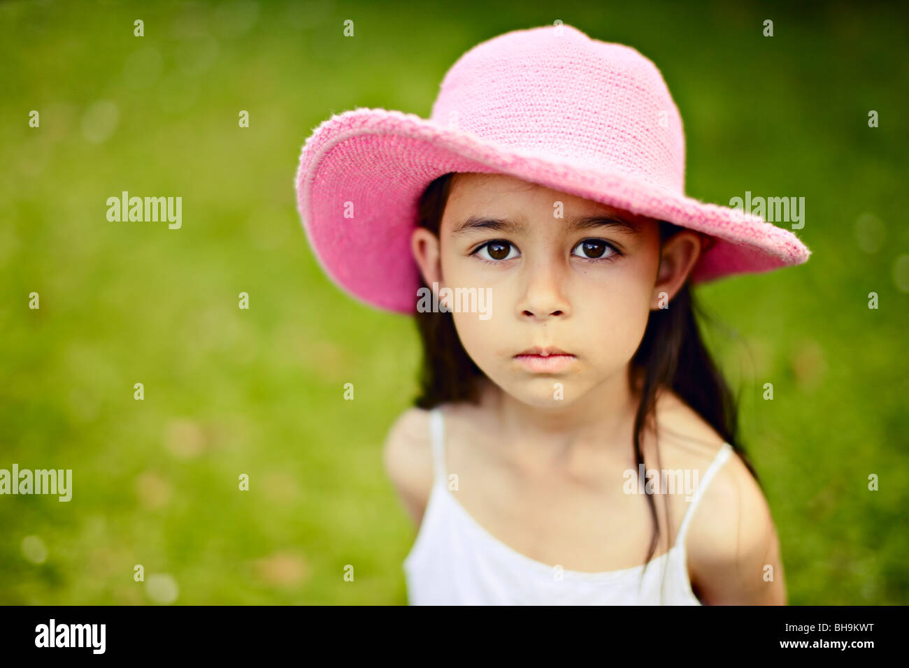 Six year old girl wearing pink hat outdoors in a garden Stock Photo Alamy