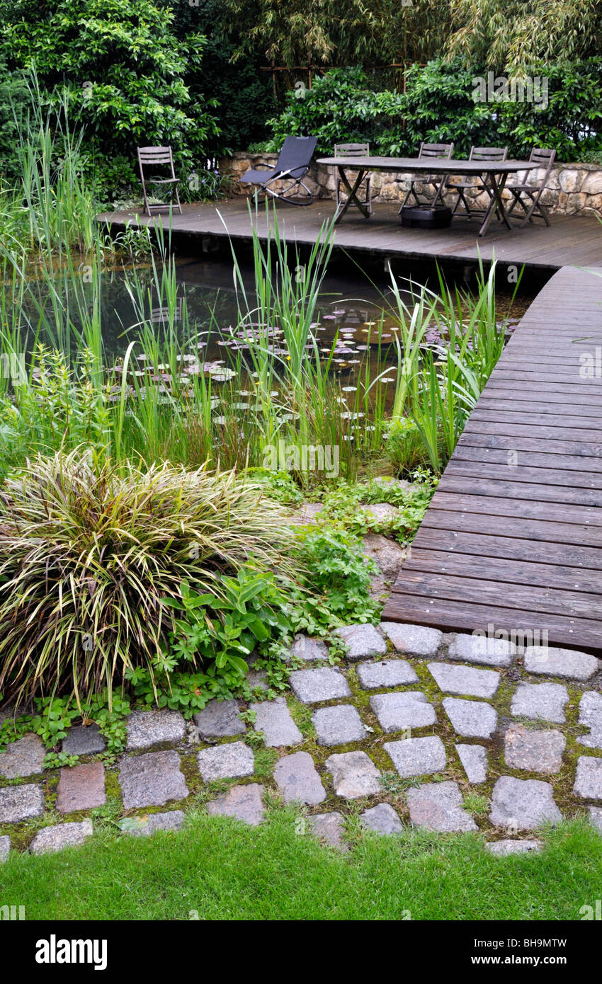 Swimming pond with wooden decking area Stock Photo