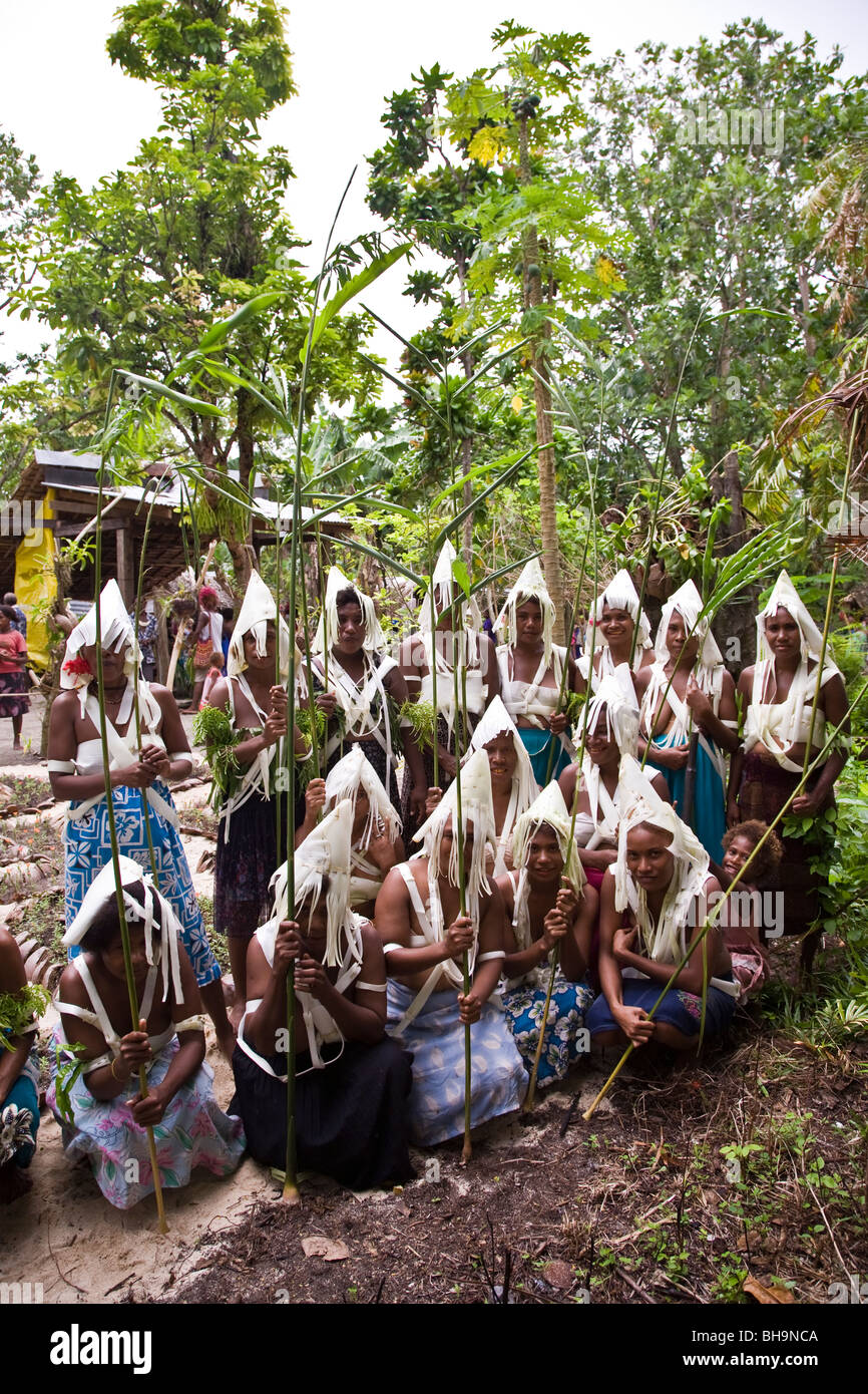 Group of Melanesian men and women wearing traditional white fringed head dress pose for camera Stock Photo