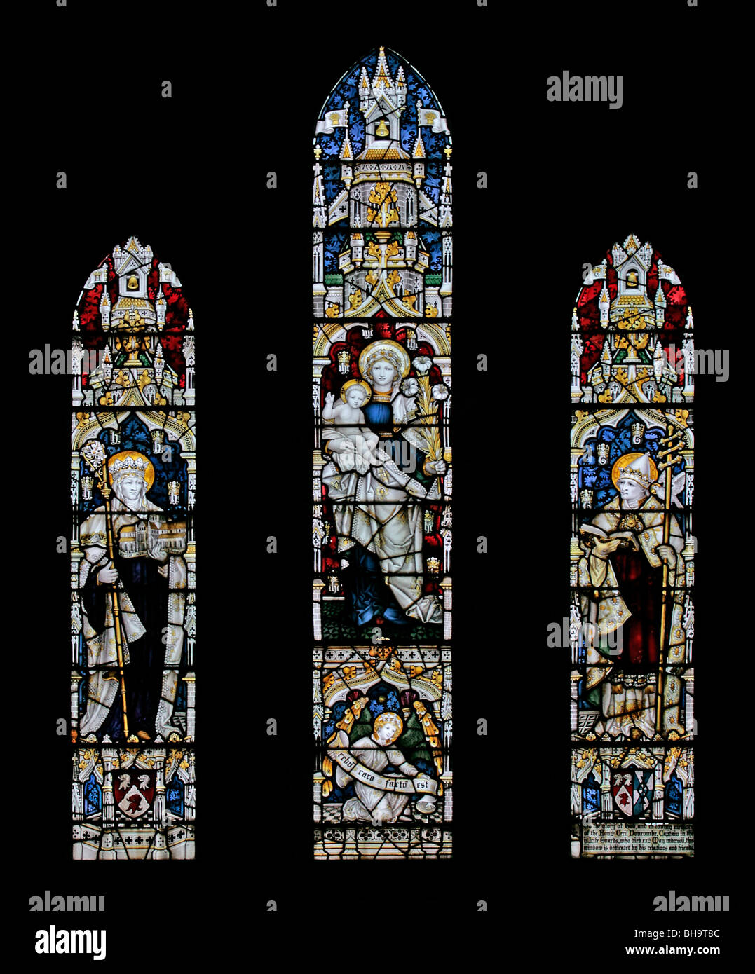 Stained glass windows by C E Kempe depicting the Virgin Mary and child, St Hilda and Saint Cuthbert; St Hilda's Church, Beadlam, North Yorkshire Stock Photo