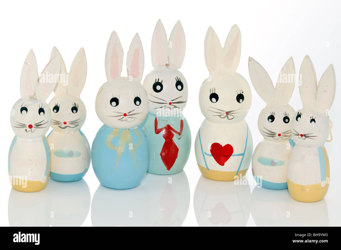 wooden easter bunnies in a row on a white reflecting background Stock Photo