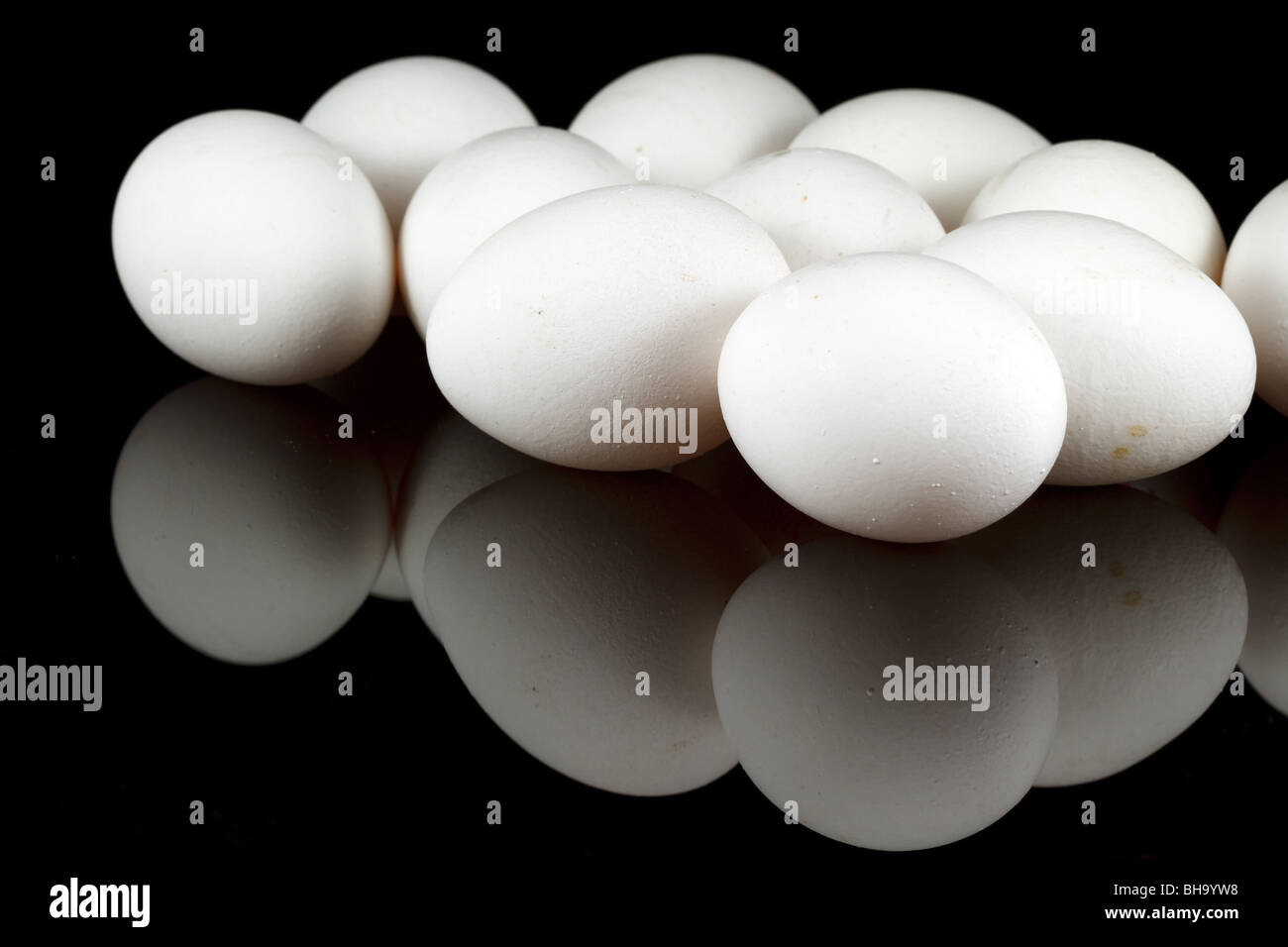 White chicken eggs on reflecting black background Stock Photo - Alamy